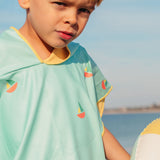 Child wearing blue hooded beach poncho after swimming lightweight microfibre towel