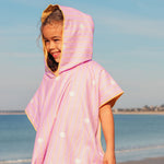 Child wearing pink hooded beach poncho after swimming lightweight quick-dry towel