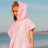 Child wearing pink hooded beach poncho after swimming lightweight quick-dry towel